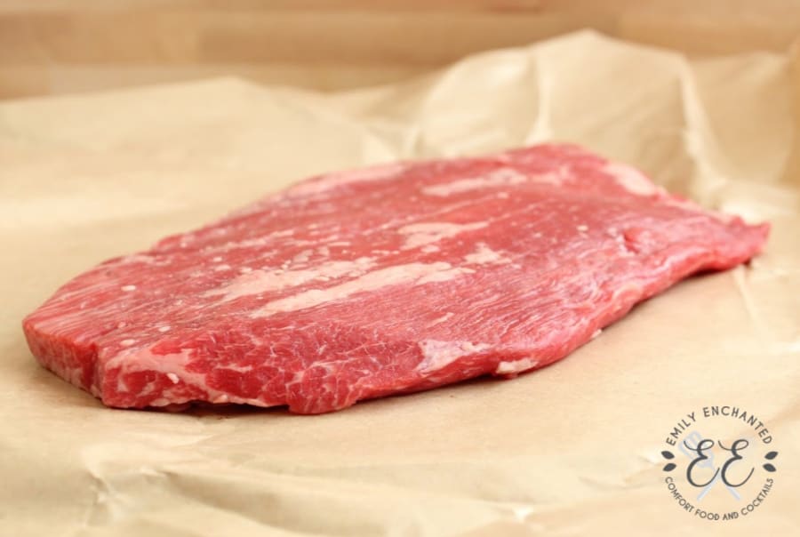 Side view of a raw large flank steak on butcher's paper