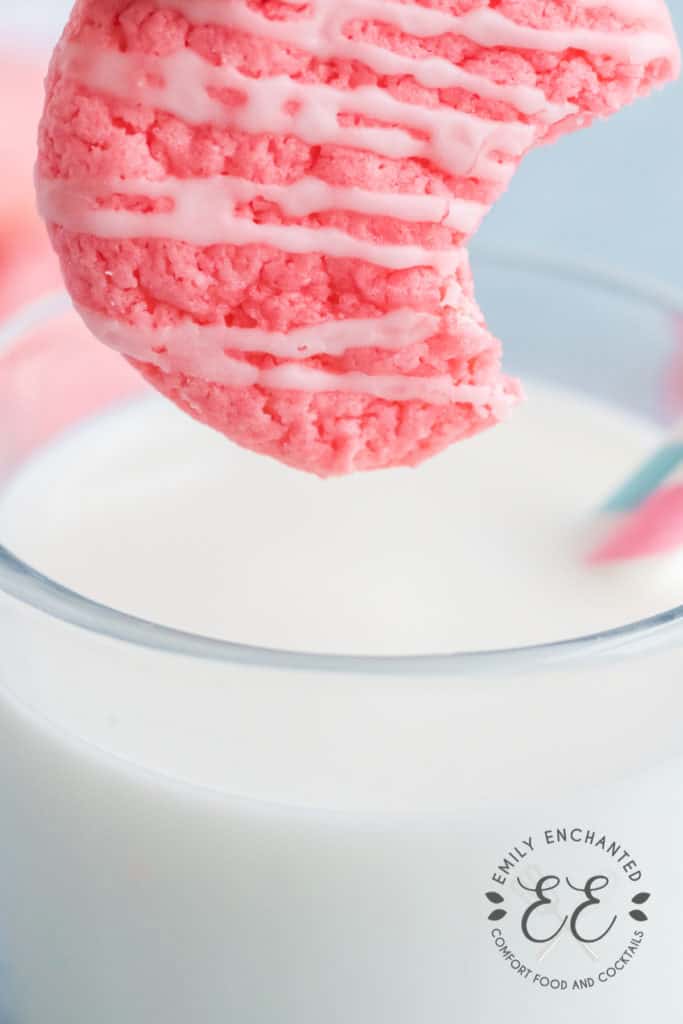 Strawberry Cake Cookie being dipped in a glass of milk