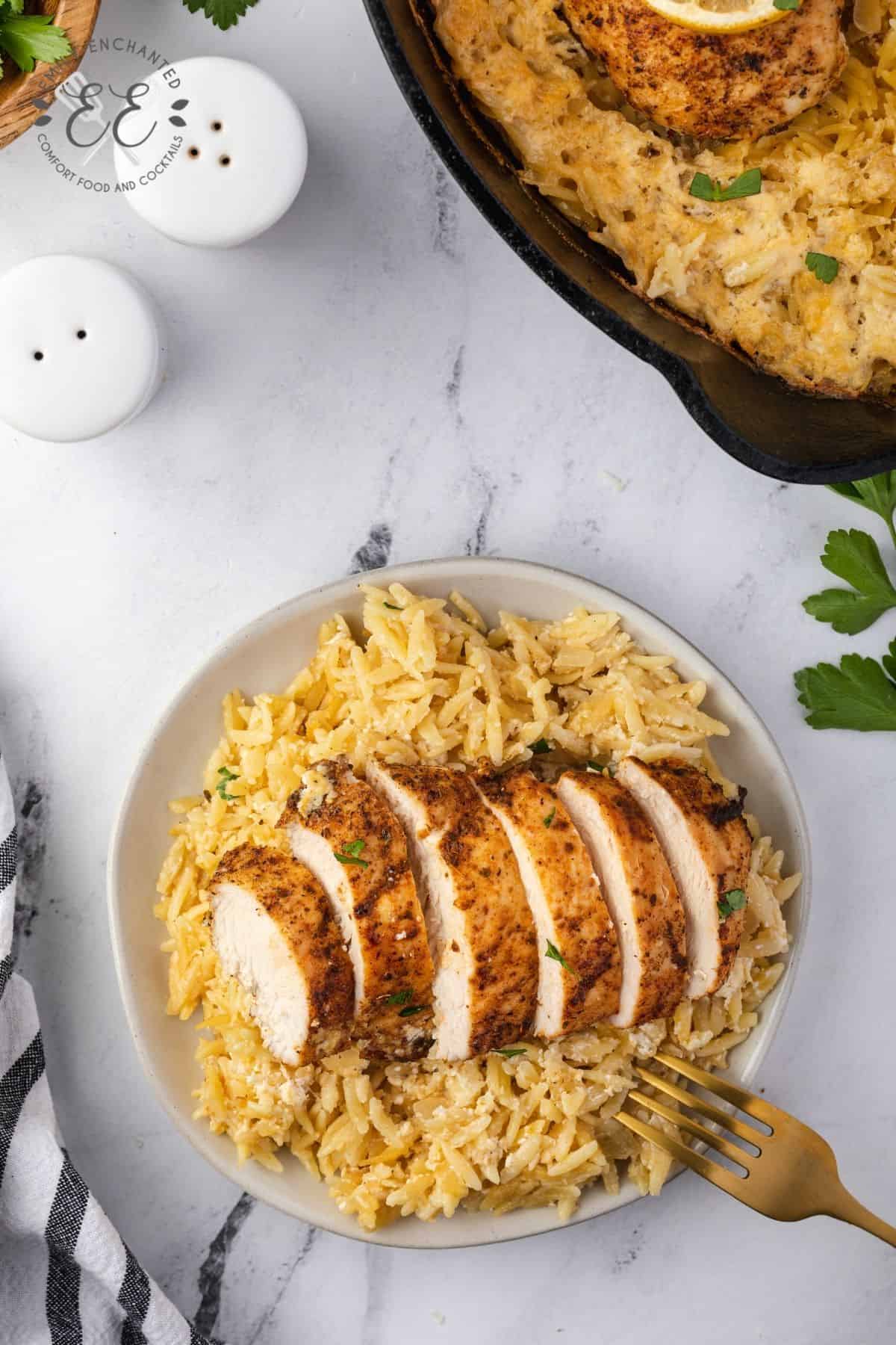 Lemon chicken breast sliced on top of creamy orzo