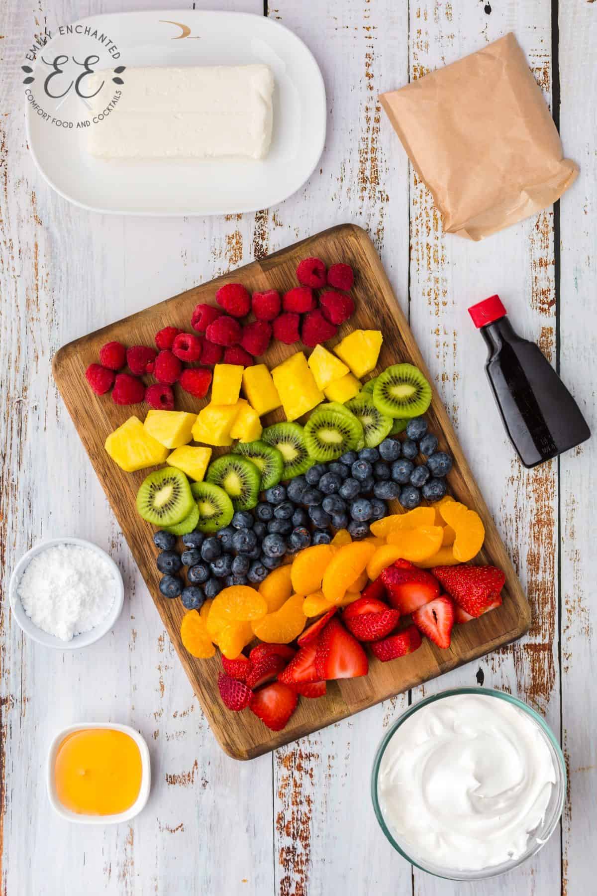 Sliced fruit and berries in rows on a cutting board