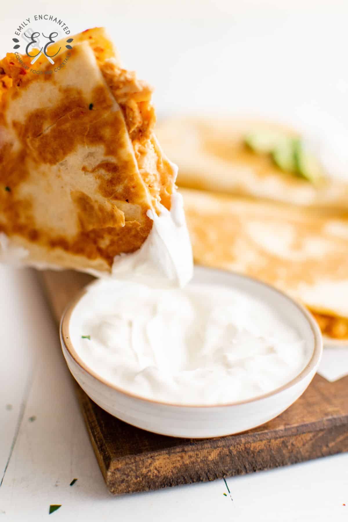 Chipotle Chicken Quesadilla dipped in Sour Cream