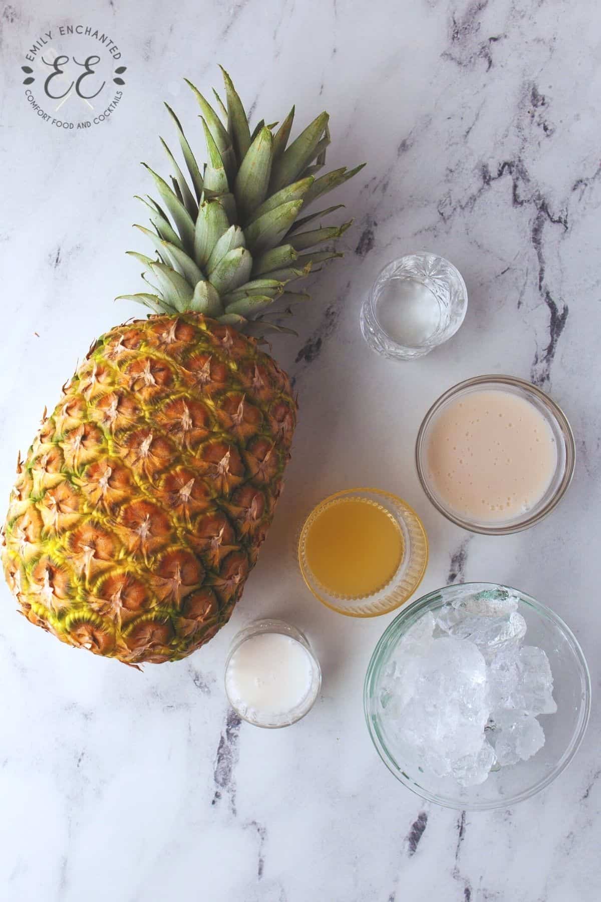 Frozen Piña Colada ingredients in a flat lay on marble surface
