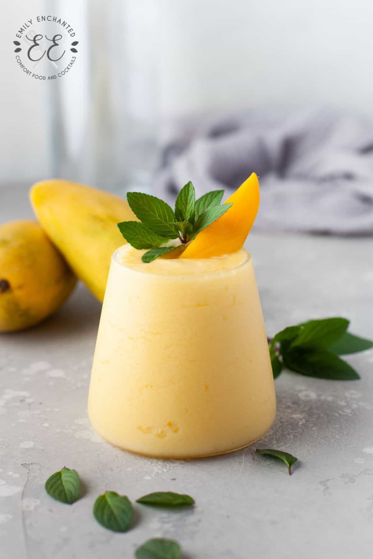 Mango Piña Colada Cocktail in a glass with slice of mango garnish