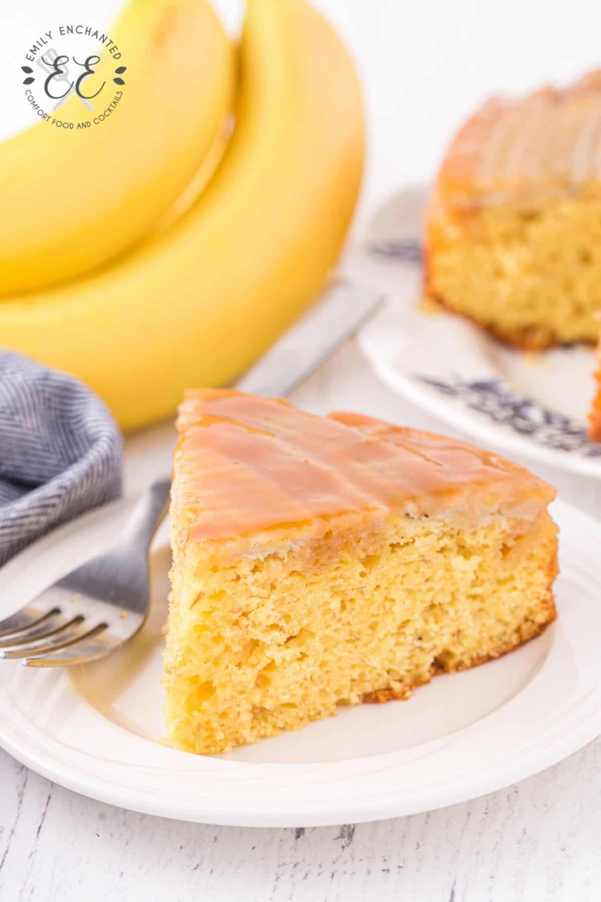 Slice of Banana Upside Down Cake on a dessert plate with a fork resting next to it