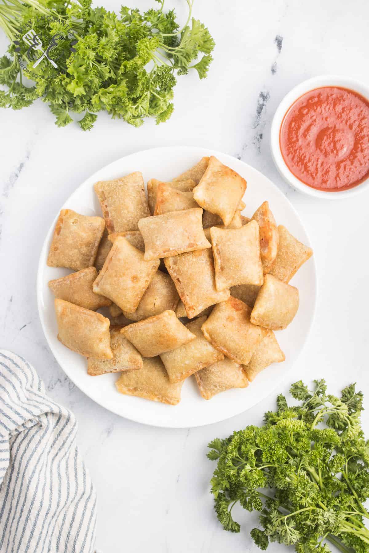 Air Fryer Pizza Rolls on a plate with a bowl of marinara dipping sauce